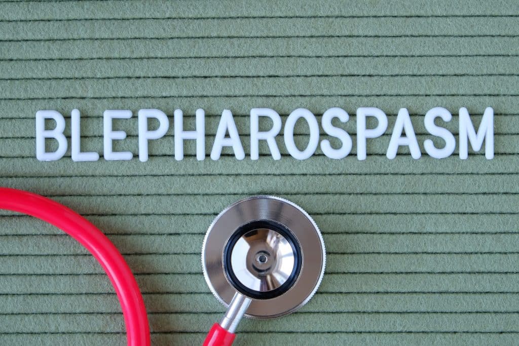 Blepharospasm- text from white letters on green background with stethoscope, medical concept diagnostics, treatment, healthcare. why does my eye keep twitching